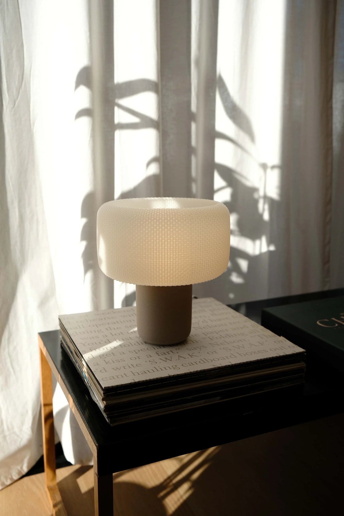 Table lamp on a side table with a soft light in a room with curtains #color_natural