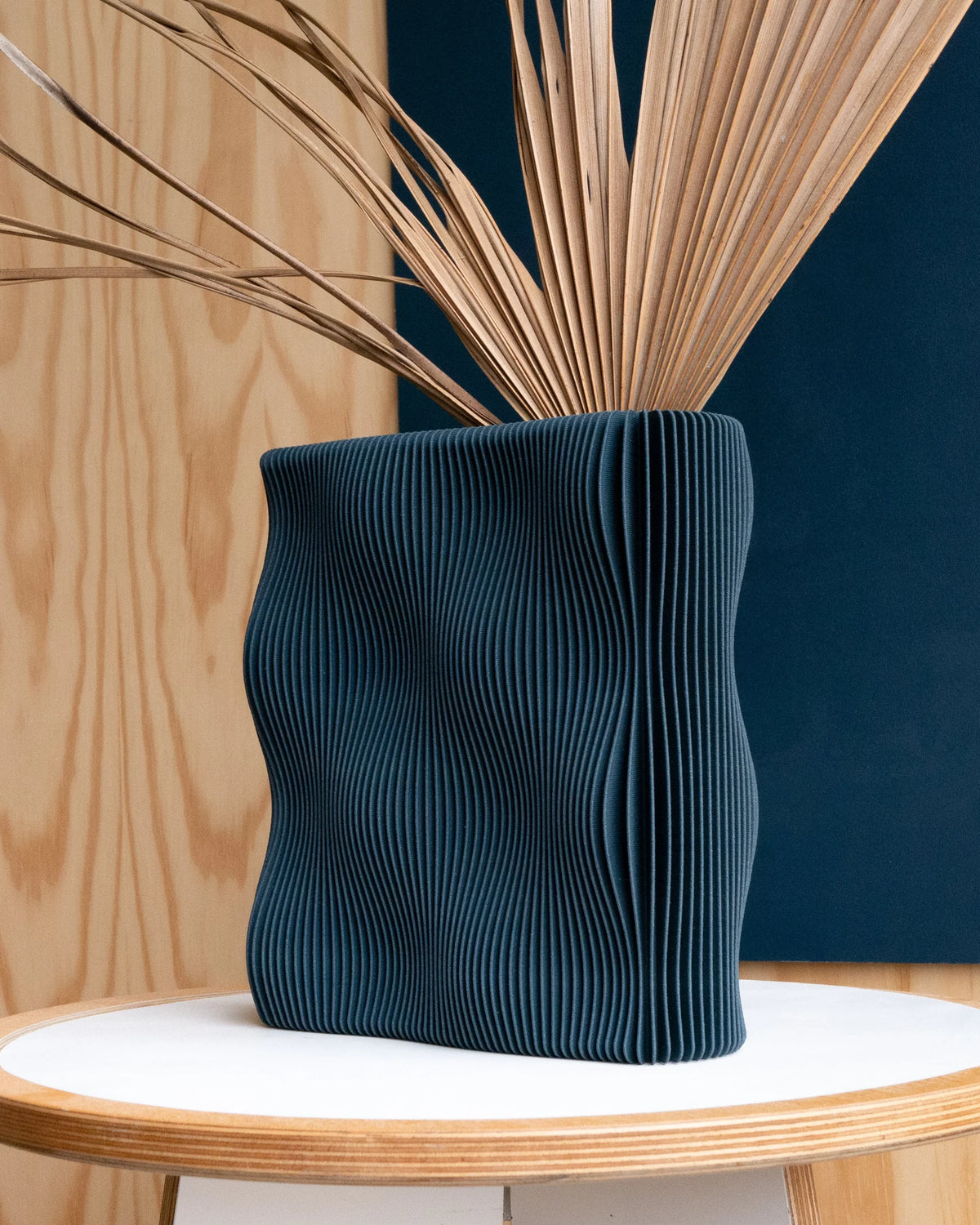 TIDE Blue sculptural vase with dried palm stems, wavy organic form, navy matte wood composite, made in France