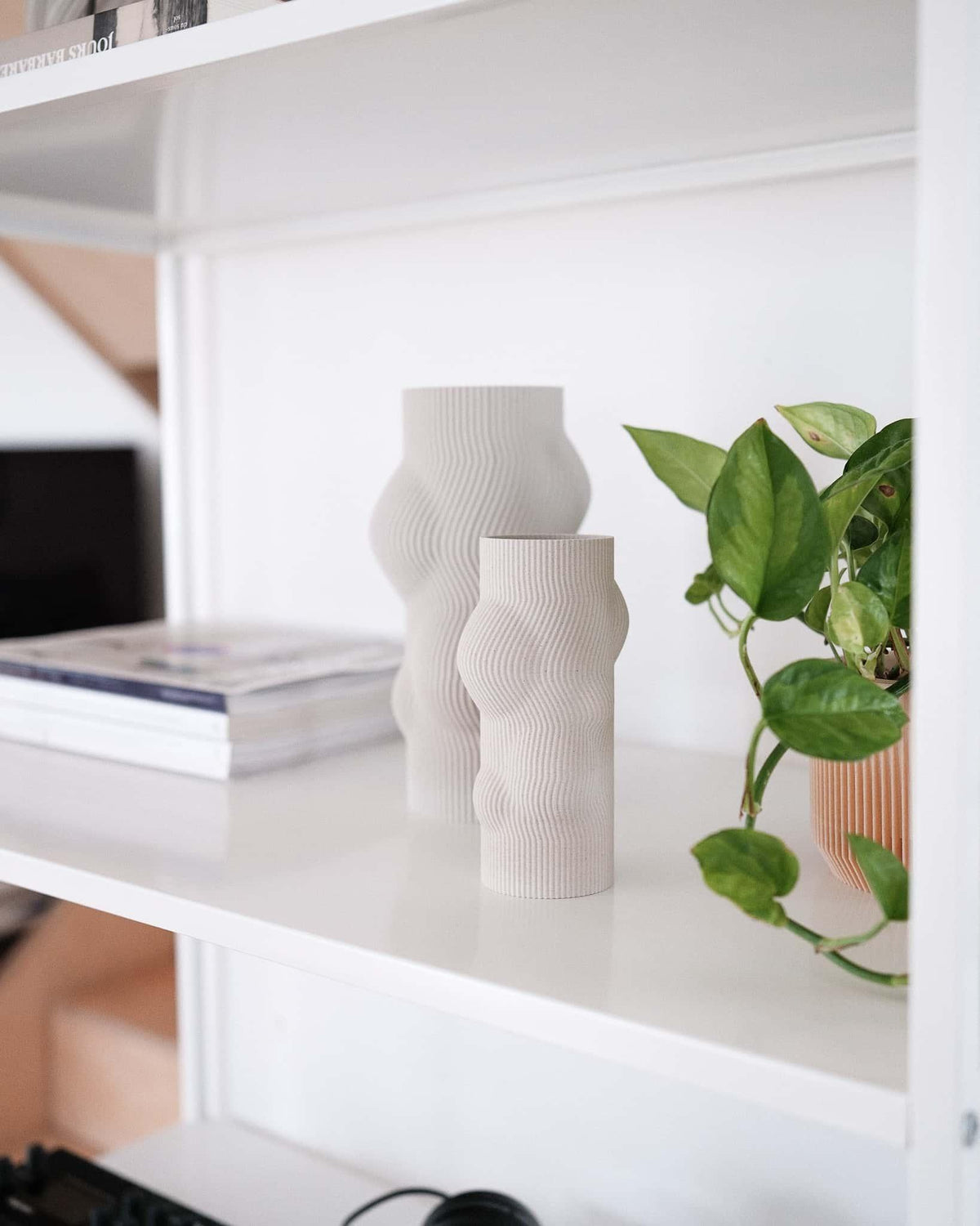White shelving unit with decorative vases and a plant