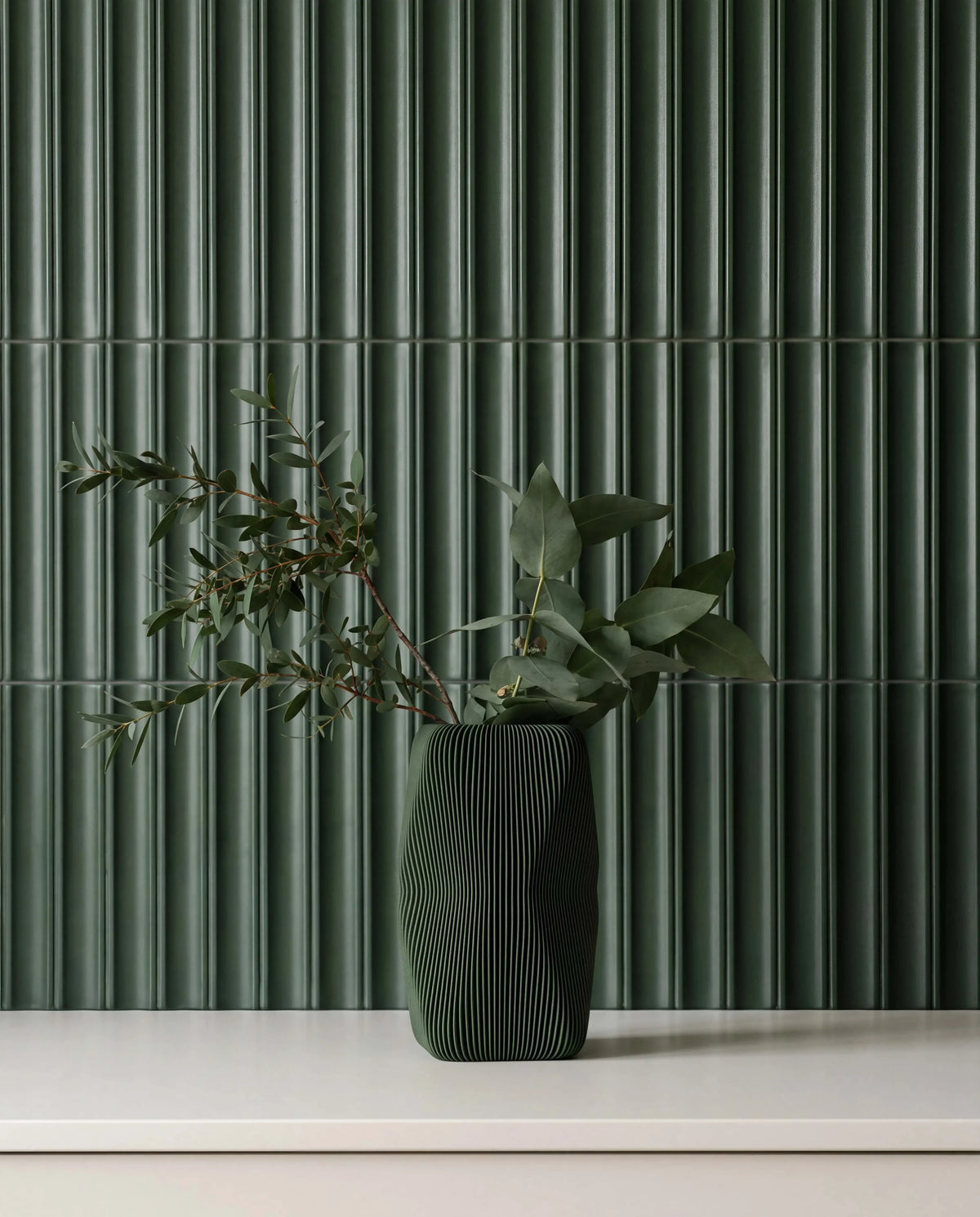Soho sculptural vase forest green with eucalyptus branches - organic sculptural vase against green tiled wall Japandi interior