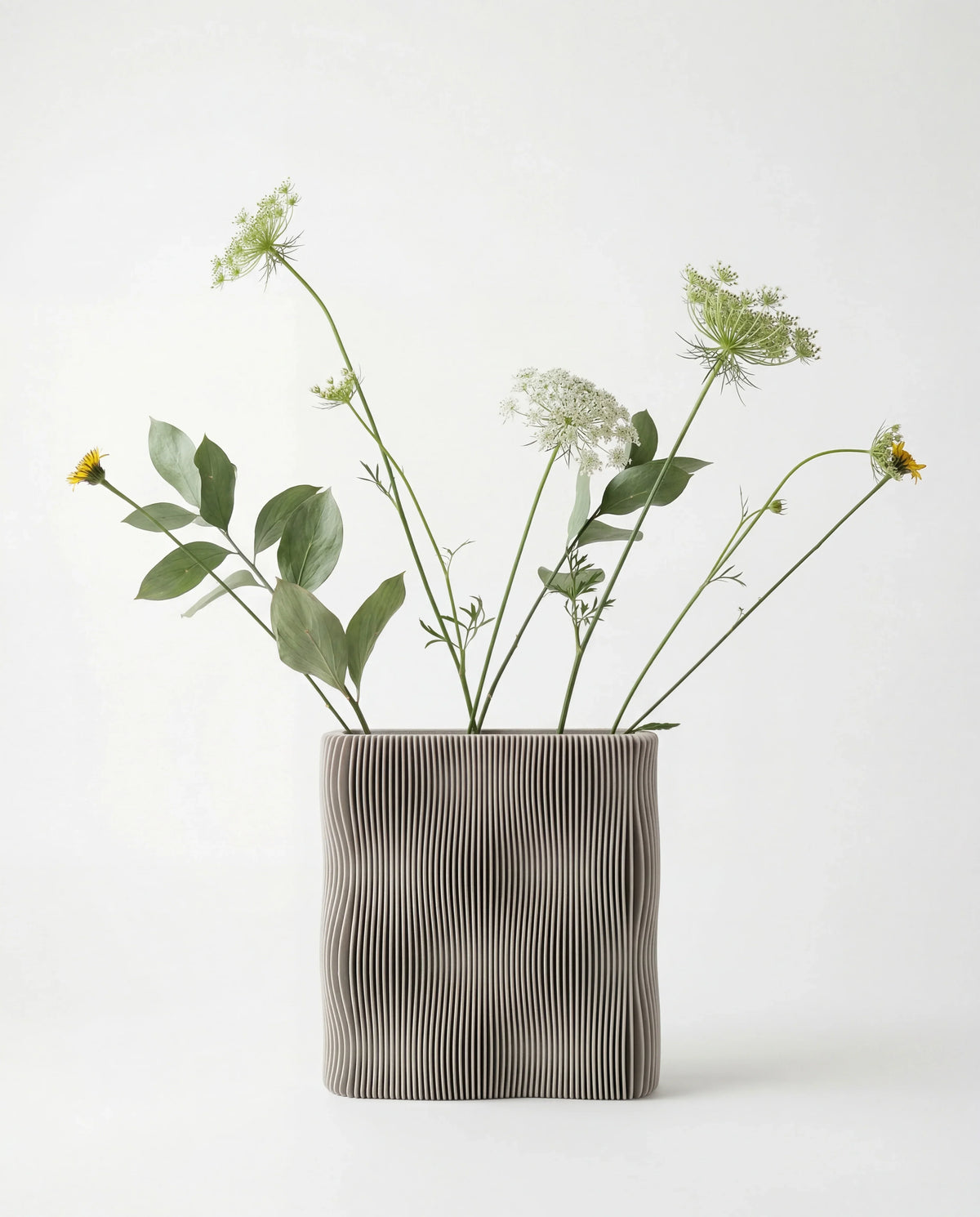 TIDE sculptural vase Mist White with wild flowers, wave-ribbed bio-sourced wood, white background, 22cm
