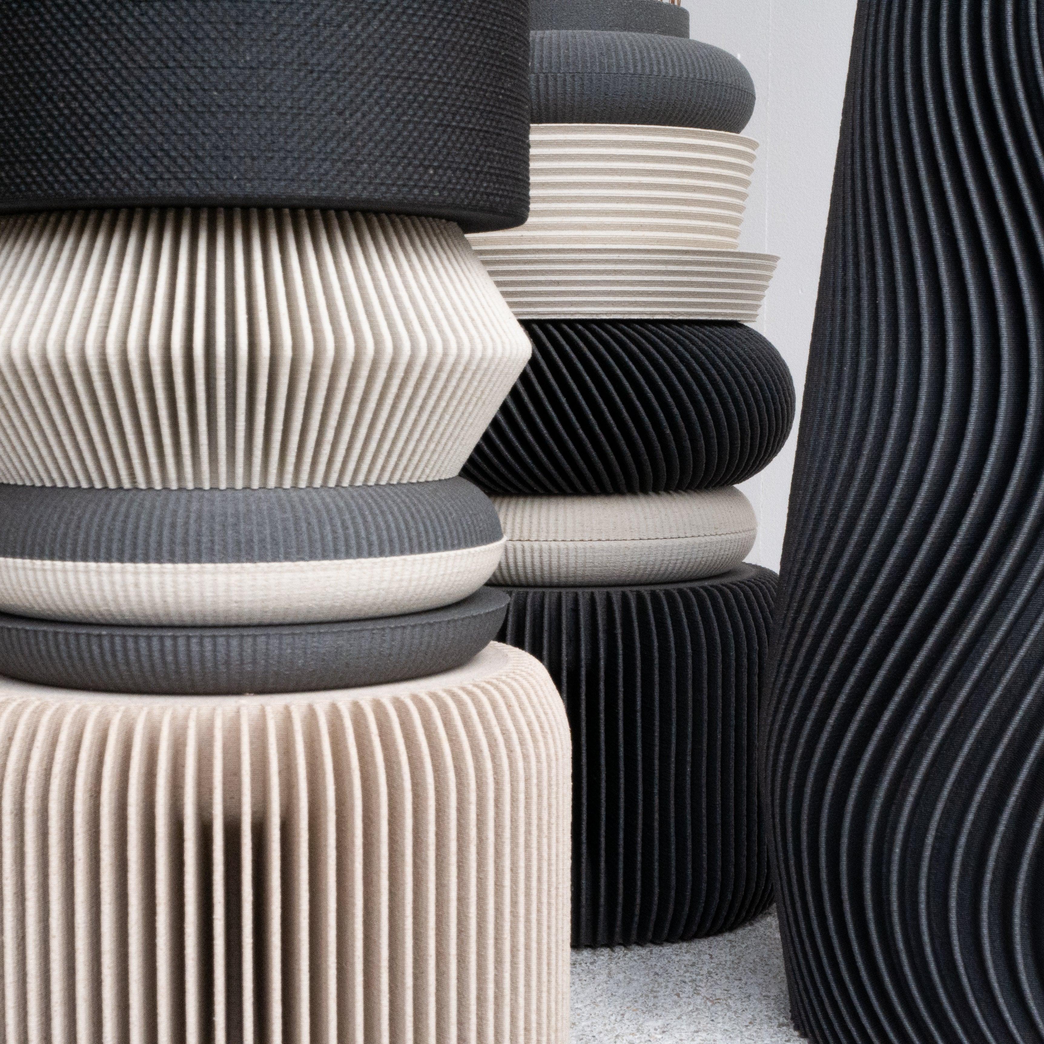 A close-up shot highlighting the smooth, matte surface of the dark grey NU vase, showing the fine texture and elegance of its bio-sourced material.