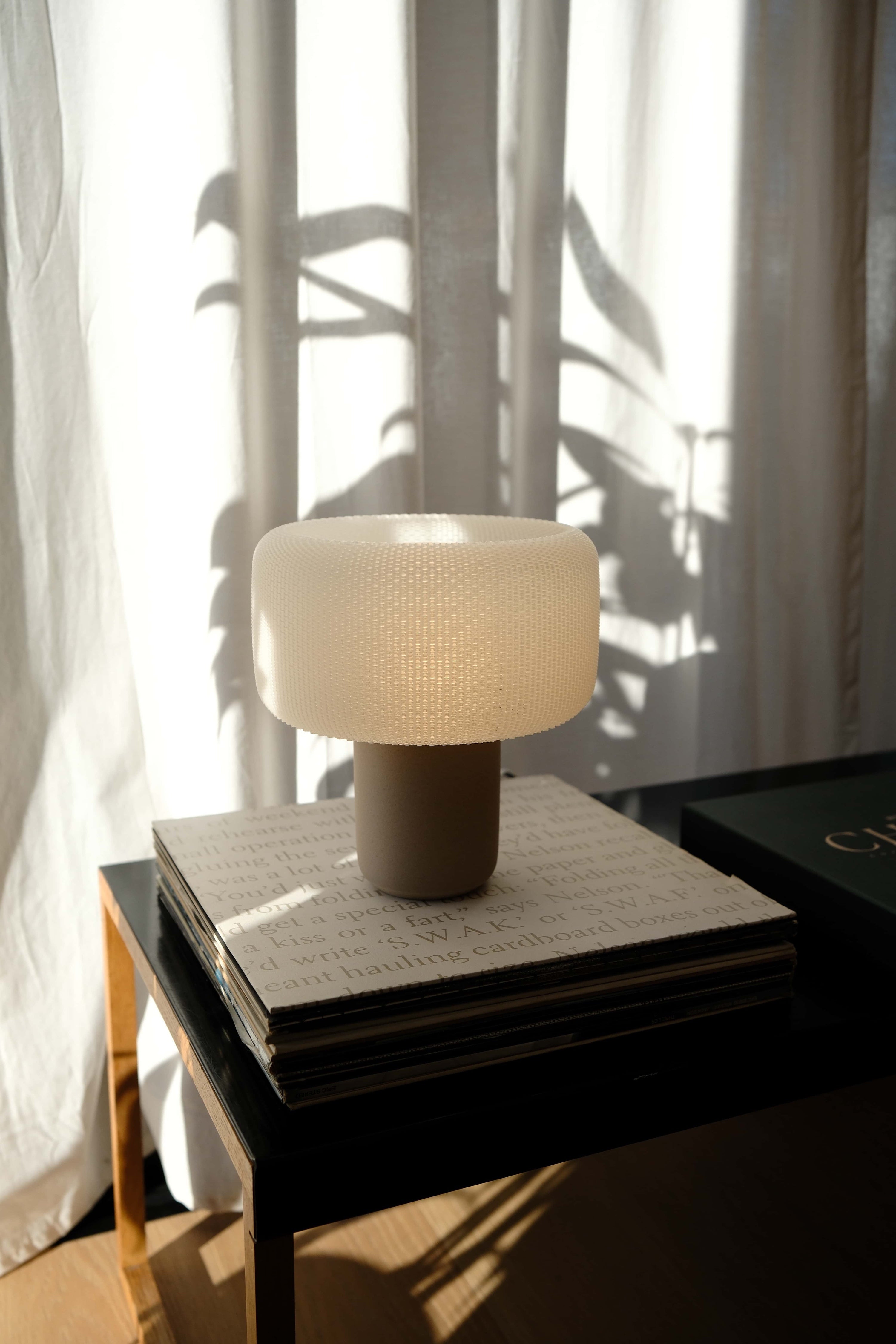 Table lamp on a side table with a soft light in a room with curtains #color_natural