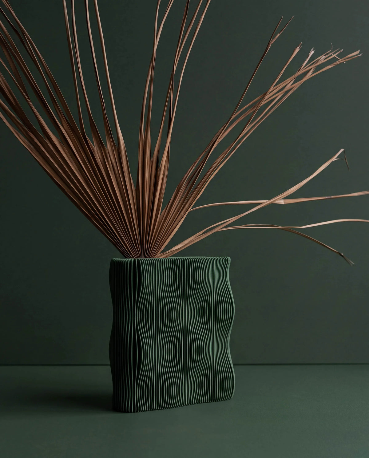 TIDE Green vase with dried palm stems, organic wave-ribbed surface, matte forest green, made in France