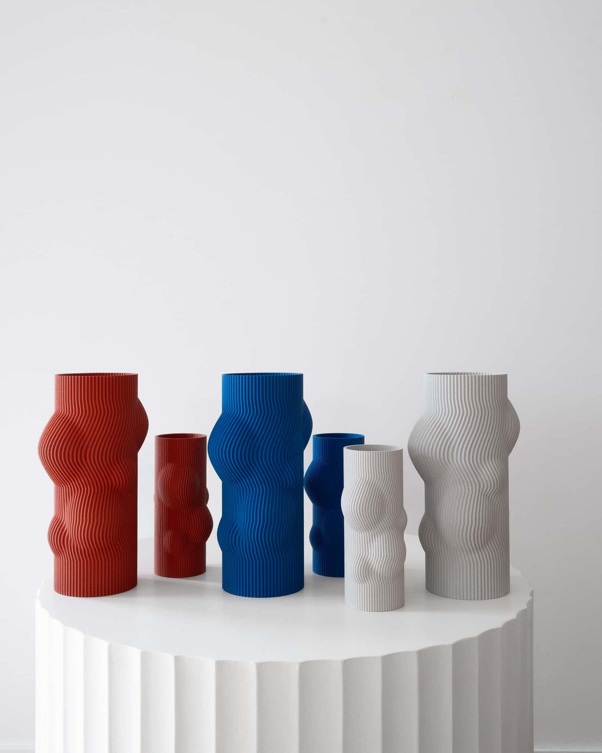 Set of colorful vases on a white surface with a white background