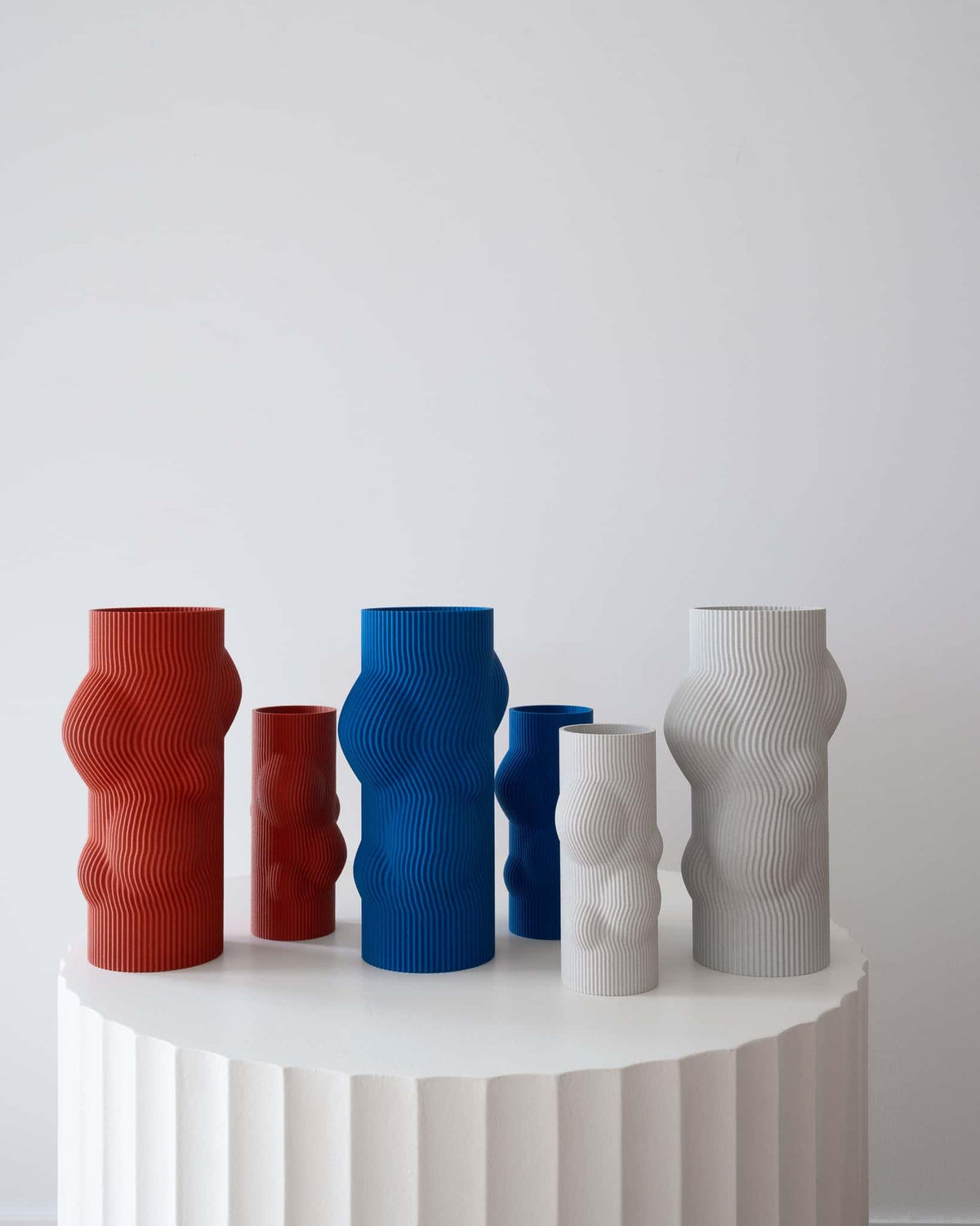 Set of colorful textured vases on a white surface with a light gray background