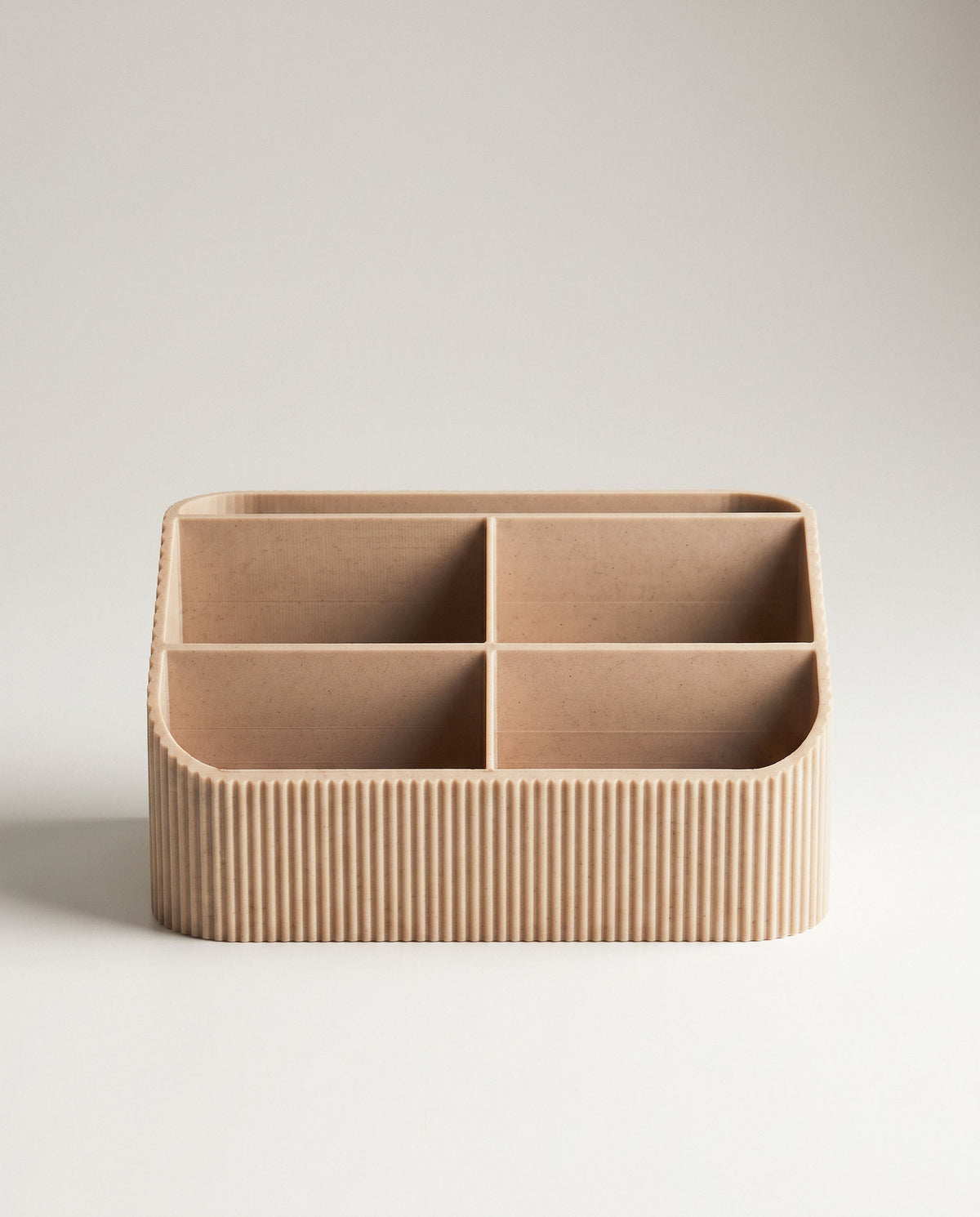 A direct, symmetrical front portrait of the empty COCO fluted desk organizer, showcasing all five interior compartments clearly. The seamless off-white background is clean and neutral, emphasizing the uniform ribbed texture and soft wood tone.