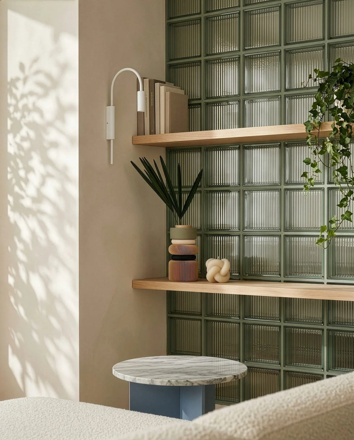 Modern interior with wooden shelves, plants, and a glass block wall.