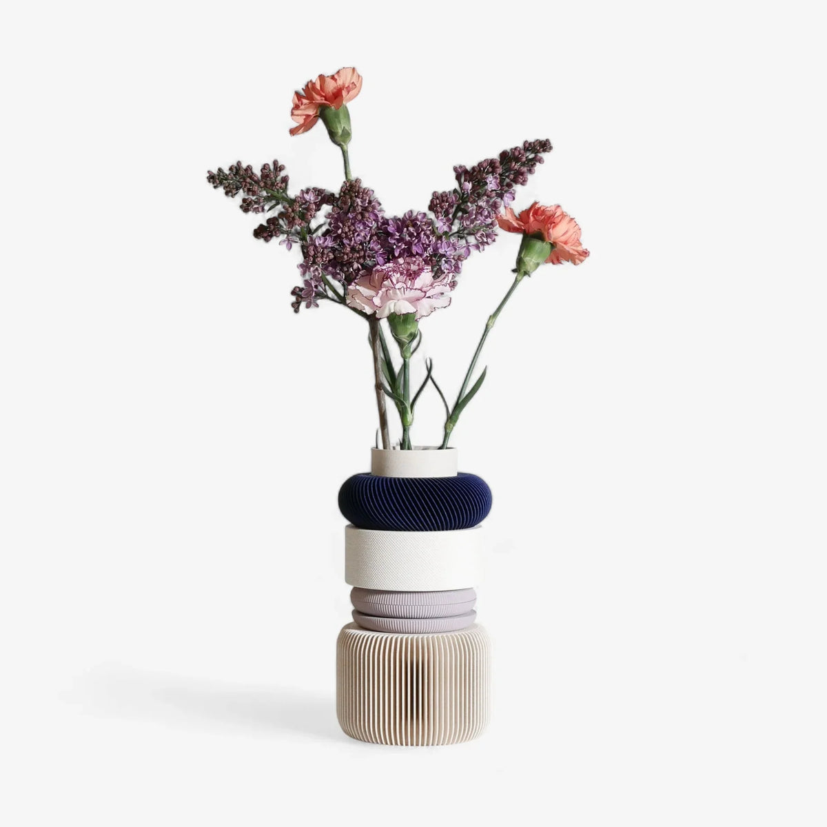 A graphic and modular violet vase, in violet and white color, with fresh flowers