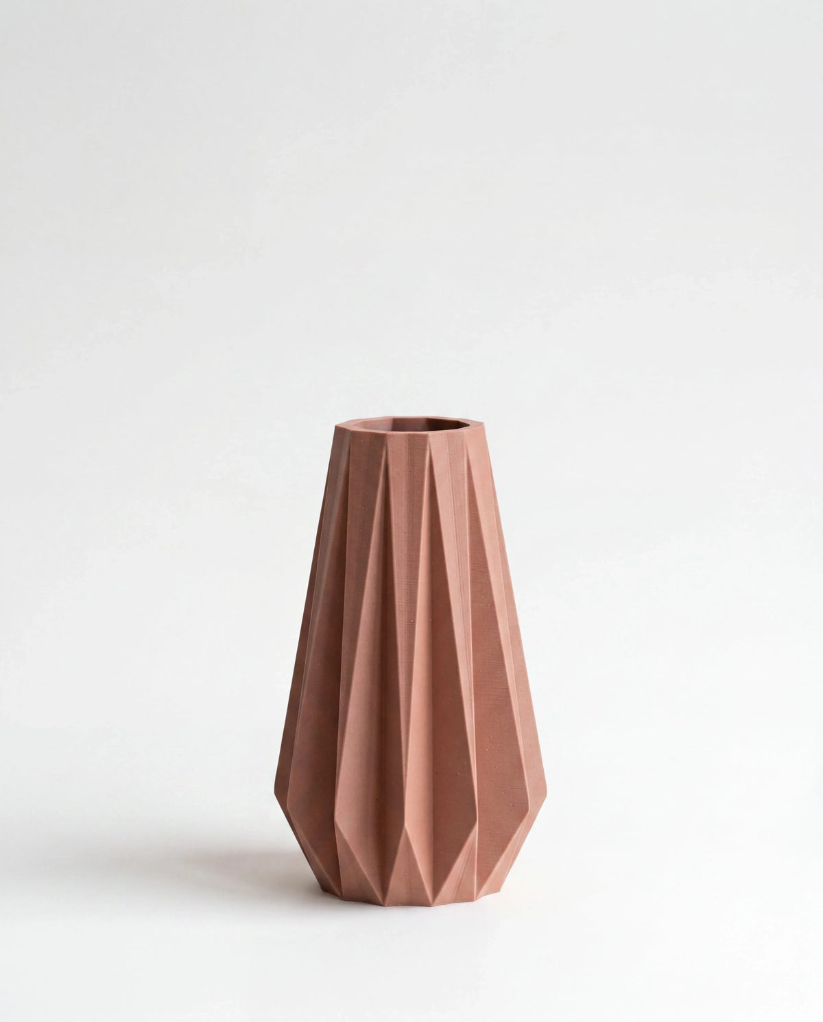 Origami vase terracotta - geometric pleated design on white background