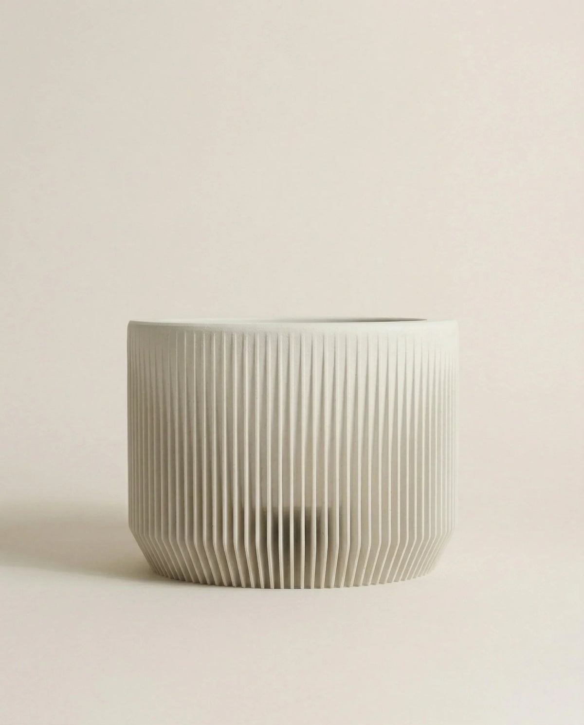 Mist white planter with ribbed texture on a light beige background