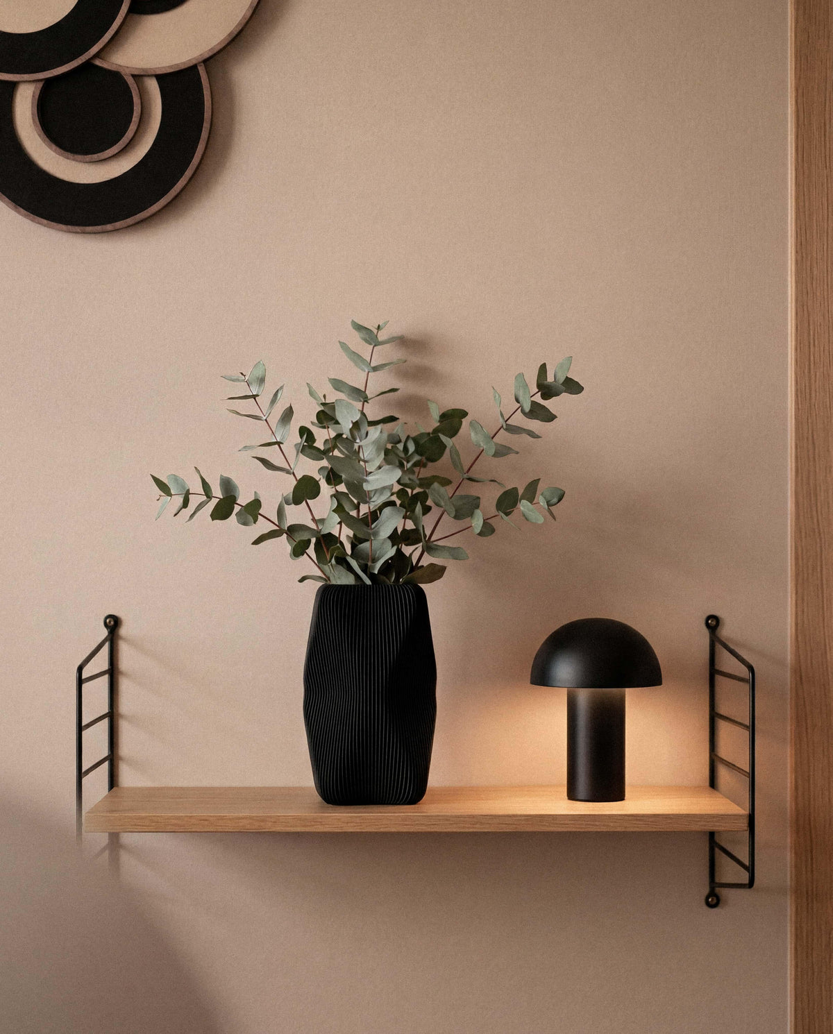 Soho black vase with eucalyptus stems on wooden shelf - minimalist home decor