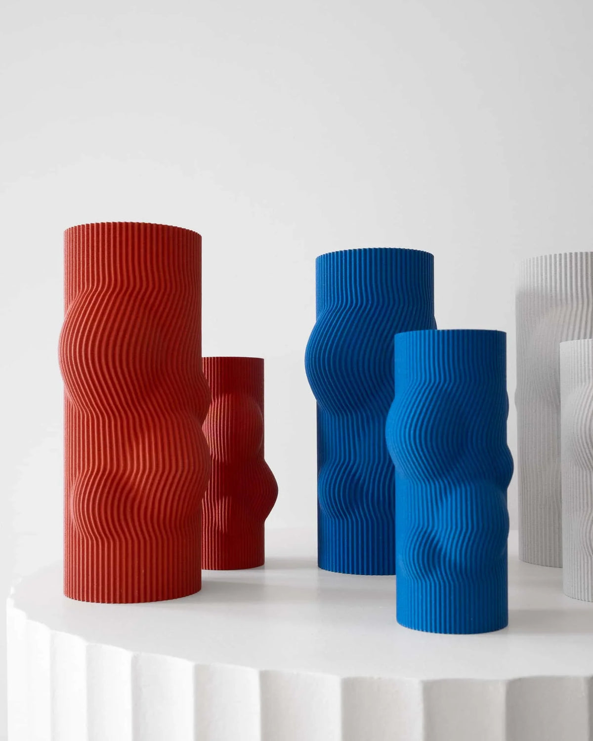 Set of colorful textured vases on a white surface with a light gray background